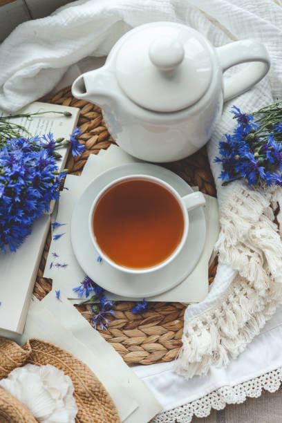istock Cup of tea, open book and cornflowers, top view 1661111613