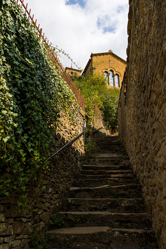 Saint-Mathieu d'Oingt church and its golden stone facade typical of this Beaujolais region from Rue du Bourg d'En Bas