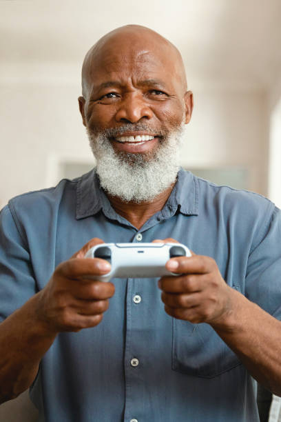 istock Senior Gamer: An Elderly Man Enjoying Video Games from His Sofa at Home 1661144536