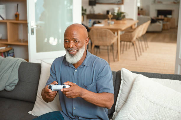 istock Senior Gamer: An Elderly Man Enjoying Video Games from His Sofa at Home 1661144905