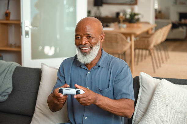 istock Senior Gamer: An Elderly Man Enjoying Video Games from His Sofa at Home 1661144906