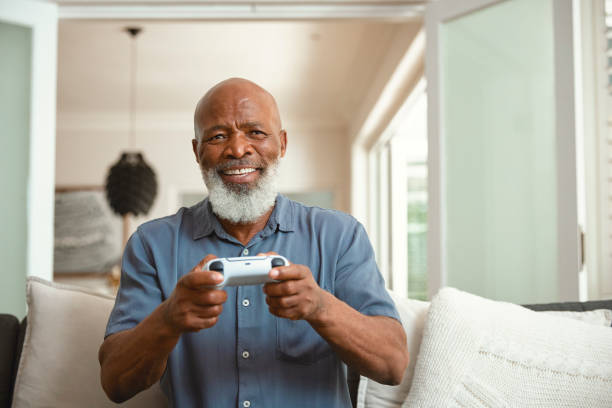 istock Senior Gamer: An Elderly Man Enjoying Video Games from His Sofa at Home 1661144916
