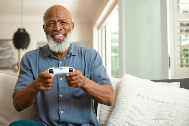 istock Senior Gamer: An Elderly Man Enjoying Video Games from His Sofa at Home 1661144939