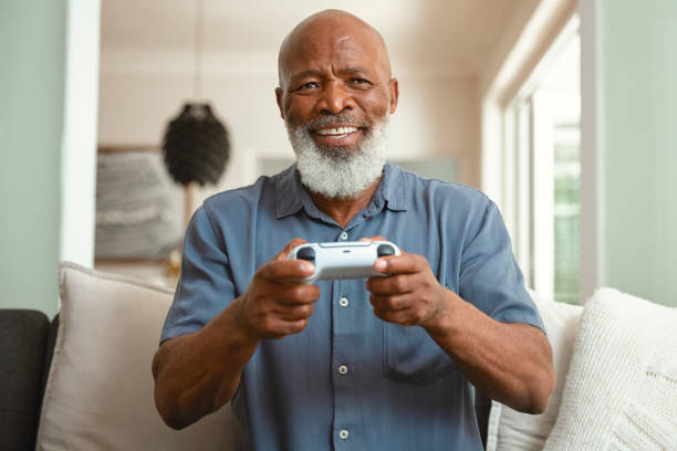 istock Senior Gamer: An Elderly Man Enjoying Video Games from His Sofa at Home 1661144976