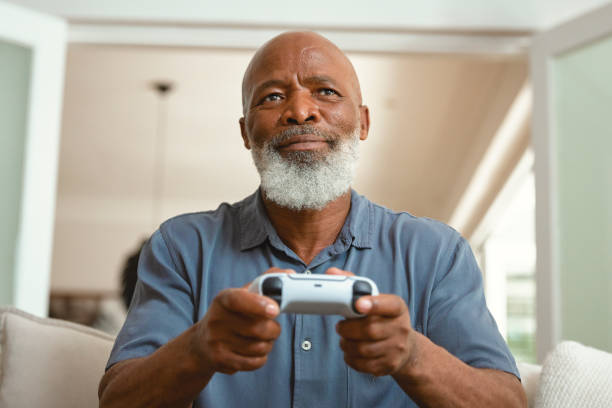 istock Senior Gamer: An Elderly Man Enjoying Video Games from His Sofa at Home 1661145452