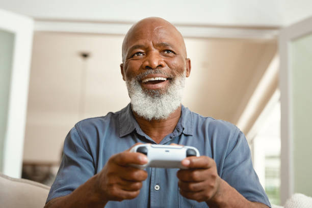 Senior Gamer: An Elderly Man Enjoying Video Games from His Sofa at Home