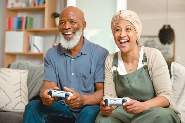 istock Elderly Couple's Fun Home Gaming Session: Playing Video Games on the Sofa 1661146073