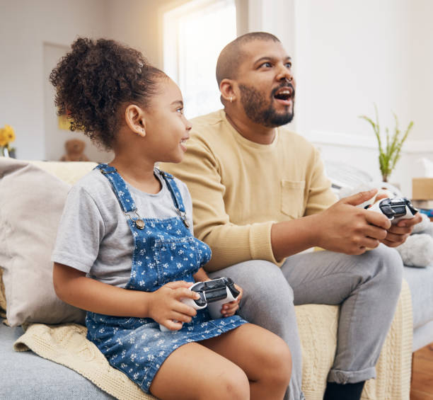 istock Father, daughter and gaming controller on sofa with challenge, press and competition for bonding in house. Man, girl child and playful with esports, contest and strategy with thinking in family home 1661151751
