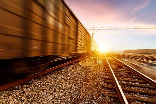 fast moving freight train, drawing out of the station At sunset, fast moving freight train, drawing out of the station freight train stock pictures, royalty-free photos & images