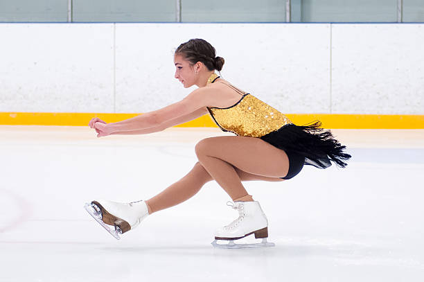 Figure skating bending down to do a spin with leg stretched A young figure skater in a spin. figure skating stock pictures, royalty-free photos & images