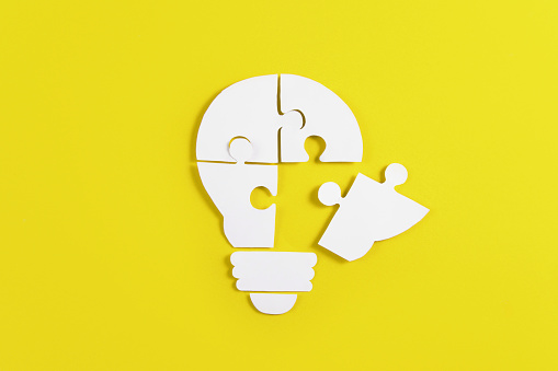 Light bulb shaped puzzle pieces on yellow background