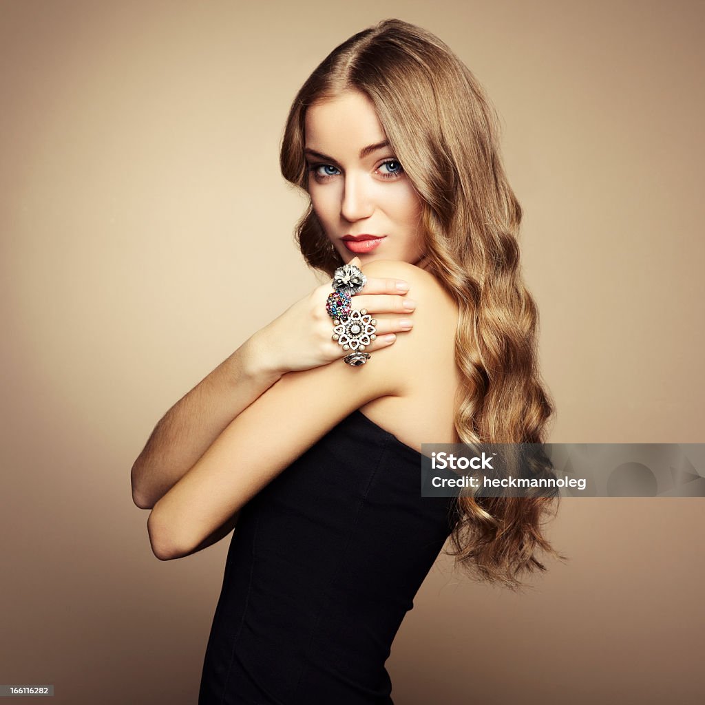 Portrait of a long blonde haired woman in a black dress Portrait of beautiful blonde woman in black dress. Fashion photo Adult Stock Photo