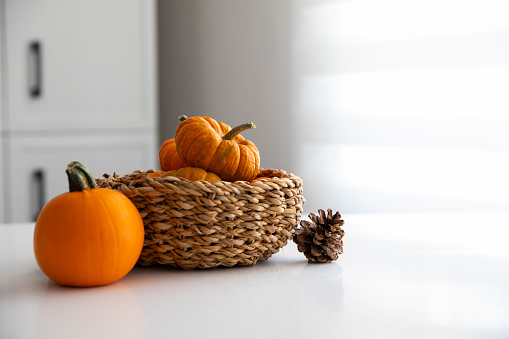 Pumpkins in a basket on kitchen counter