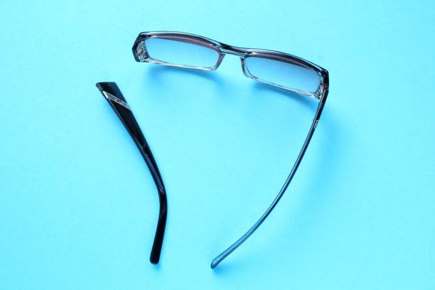 istock Old broken eyeglasses with damaged legs on blue background. Poor eyesight. Reuse and repair concept. Idea of health. Failure optic eyewear. Breakage of vision correction glasses. Close up, flat lay 1661167576