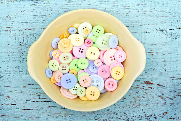istock Pastel color buttons in a yellow bowl 166119904