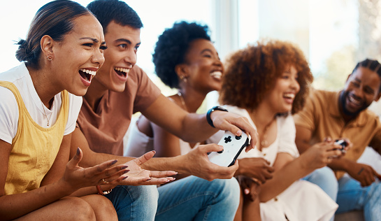 Friends together on sofa, video game fun and relax in home living room playing with internet controller. Online gaming, virtual esports app and couch happy group of gamer men and women in apartment.