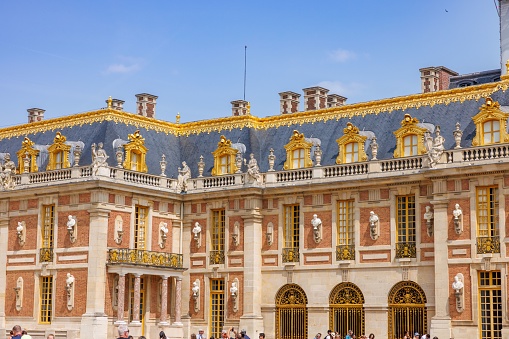 Paris, France – June 30, 2023: A large palace with gilded exterior, opulent adornments and blue skies