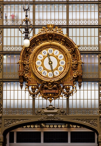 Paris, France – June 29, 2023: Musee d'Orsay gilded clock in Paris France An antique clock mounted on a white wall inside of amuseum