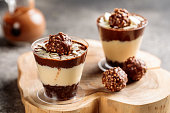 Ferrero rocher cheesecake served in cup isolated on wooden board top view cafe cheese cake food dessert
