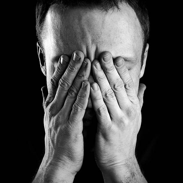 istock A stressed Caucasian man covering his face with his hands 166122472