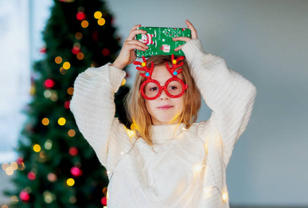 istock young girl holding large Christmas gift 1661226693