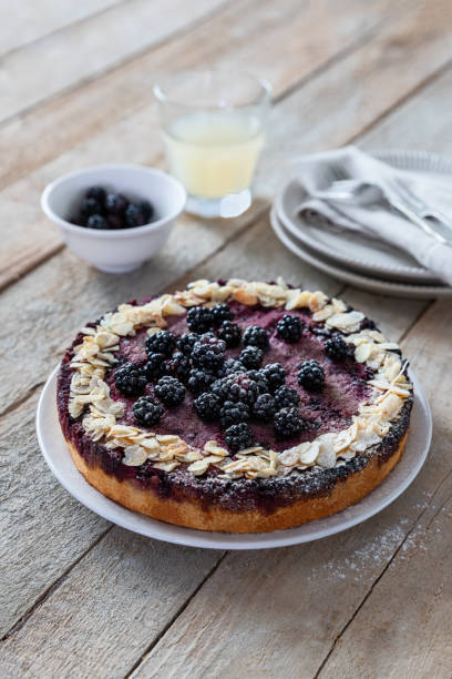 istock Blackberry cake on wooden table angle view from above 1661231688
