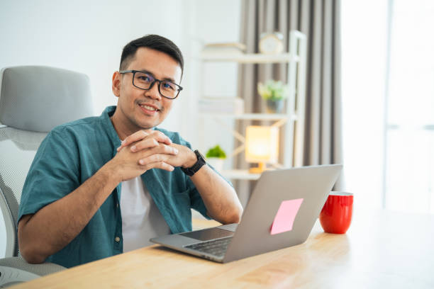 istock Smart Asian man smiling wearing glasses working with computer laptop. concept work form home, stay at home. freelance life style, New normal social distancing lifestyle. Work form anywhere concept. 1661241130