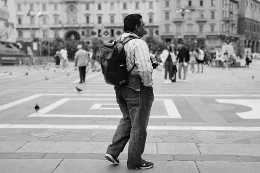 Milano, Italy - September 05, 2023: a photographer walking in Duomo Square  in Milan