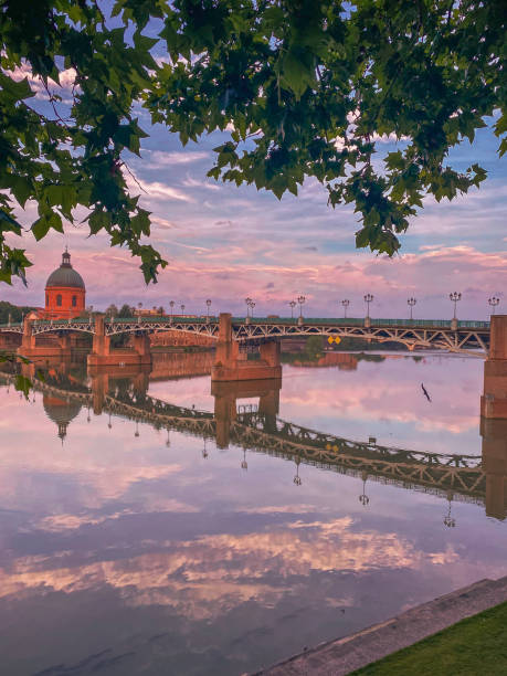 View of the dome of the Grave and Saint Peter bridge from the quays near the Pont Neuf in Toulouse city during a pinky  cloudy morning