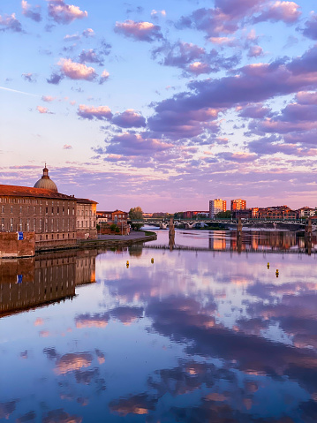 View of the Garonne river from the quays near the Pont Neuf in Toulouse city during a pinky  cloudy morning