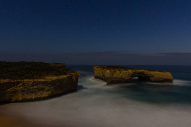 лондонская арка на великой океанской дороге ночью в австралии - london arch great ocean road cliff australia стоковые фото и изображения