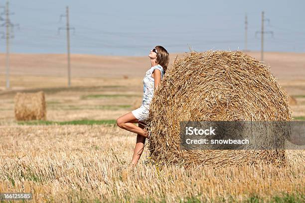 Mädchen Und Runde Heuhaufen In Das Feld Stockfoto und mehr Bilder von Ausgedörrt - Ausgedörrt, Ernten, Erwachsene Person