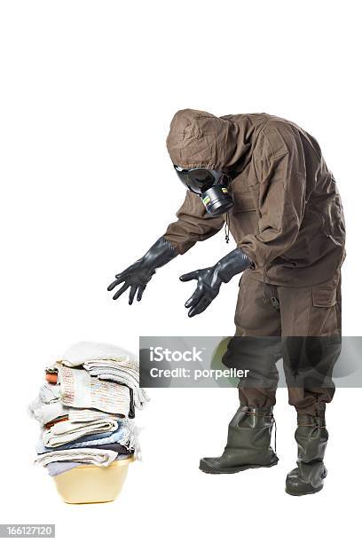 Man In Hazard Suit Looking At Dirty Laundry Stock Photo - Download Image Now - Dirty, Gas Mask, Laundry