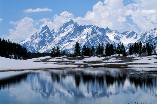The Teton Mountains, of Wyoming are reflected in a lake