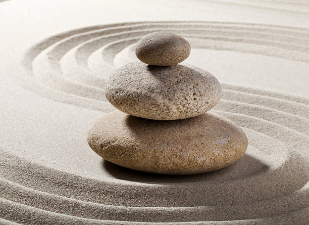 istock Zen relaxation pebbles in swirled sand. 166127325
