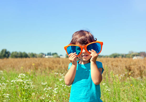 istock Little girl looking through a big sunglasses 166127536
