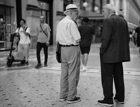 Milan, Italy - September 05, 2023: two elderly gentlemen are talking in Galleria Vittorio Emanuele