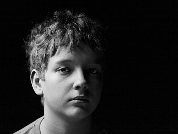 portrait de triste petit garçon sur le noir - little boys child sadness depression photos et images de collection