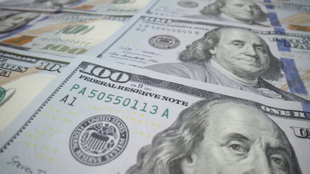 Close-up one hundred dollar bills, US dollars paper money cash, detailed American banknotes macro slide dolly shot