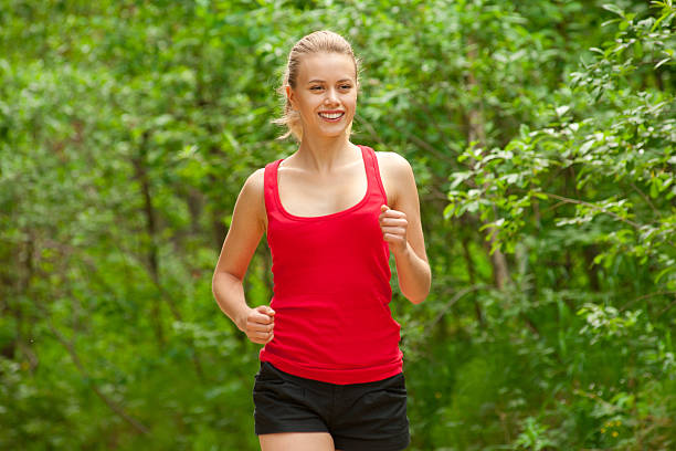 istock Young woman jogging outdoors 166130420