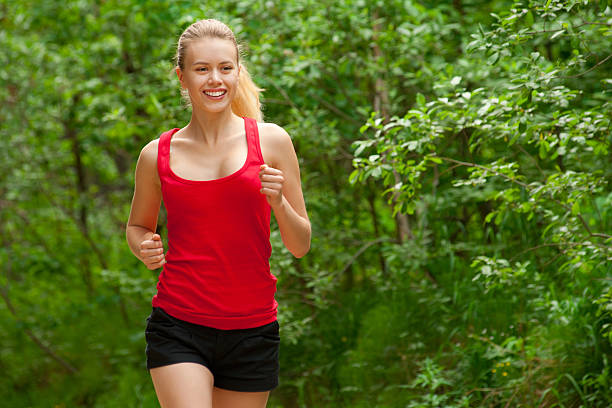 istock Young woman jogging in park 166130425