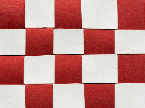 Interwoven red and white paper strips make a striking checked pattern.