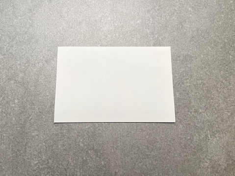 Empty white card on the gray background with copy space