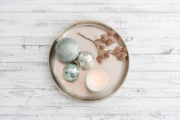 Tray with christmas decorations and candle on white wooden background, top view