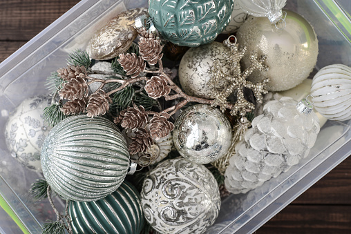 Box with christmas decorations on wooden background, top view