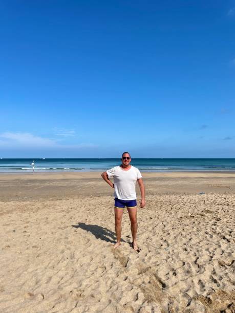 istock Man on a beach in swimming shorts. 1661353574
