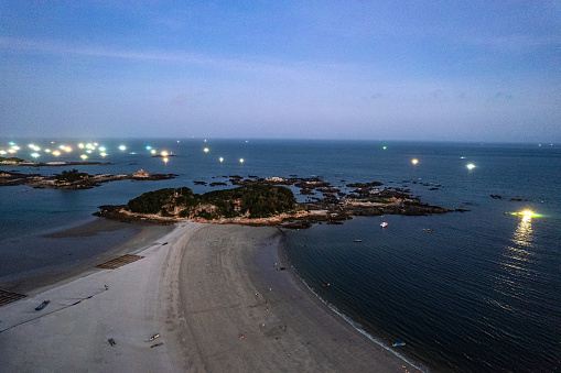 Aerial view of the seaside town and fishing boats at dusk