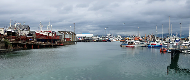 Malliag, Scotland, United Kingdom, July 7, 2023. Harbour and marina with moored boats and port buildings. Outdoors on an overcast summer day.