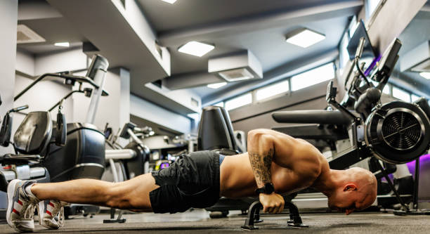 istock Man exercises push-ups in the gym 1661370501
