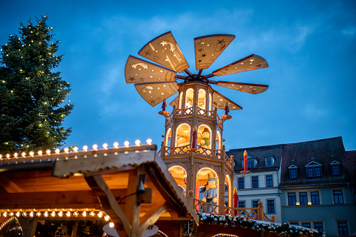 illuminated public christmas market with pyramid and decorated tree in the historic town of weimar, germany
